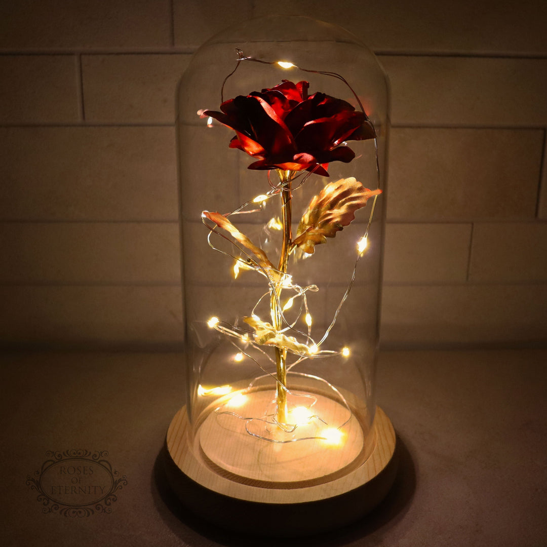 Regalo de aniversario: rosa dorada eterna con luz LED bajo cúpula de vidrio, símbolo de amor duradero.