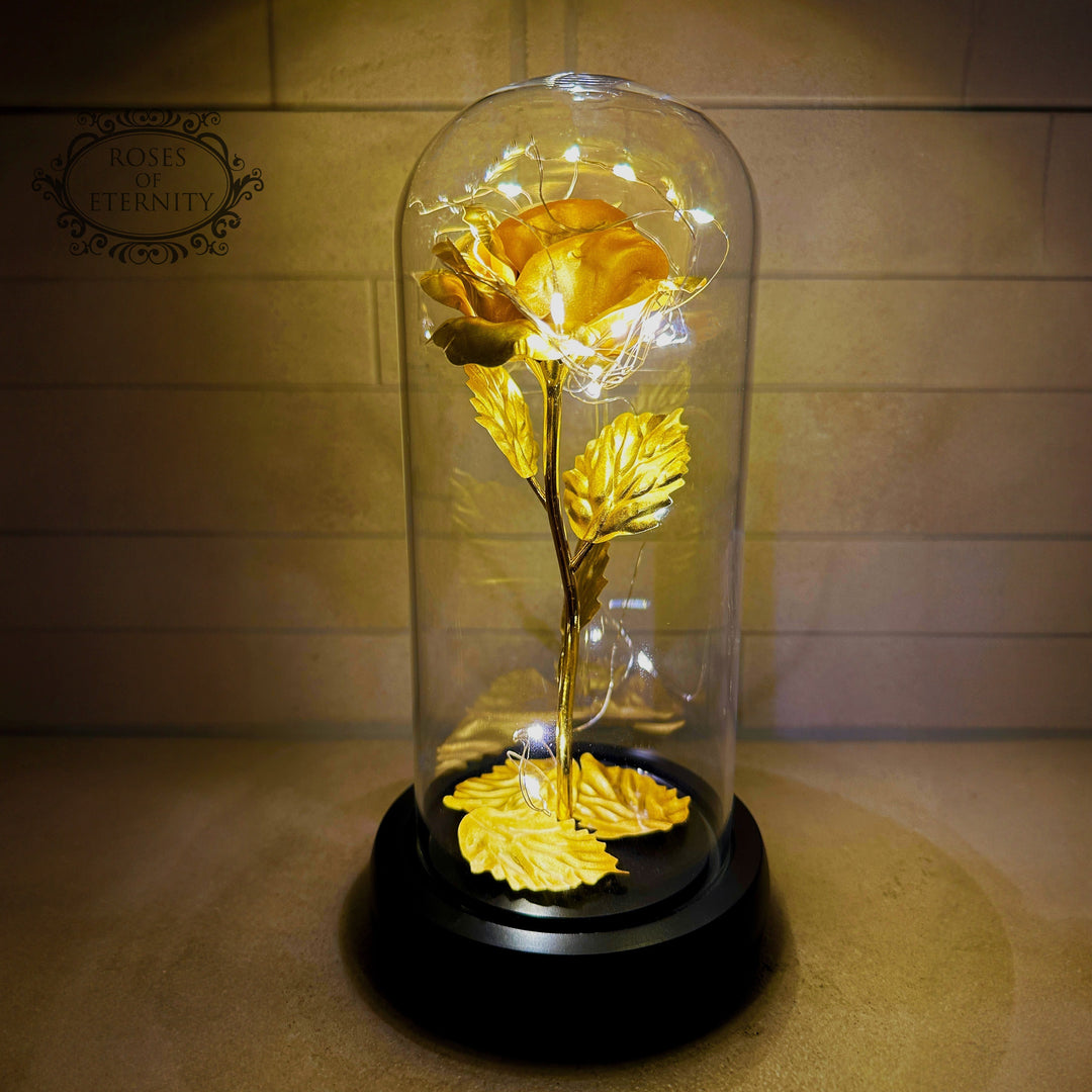Regalo especial: rosa eterna dorada con luz LED en campana de vidrio, ideal para momentos memorables.