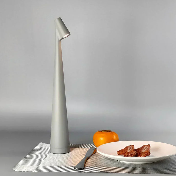 Detalle de lámpara de mesa LED inalámbrica regulable, diseño nórdico minimalista y portátil.