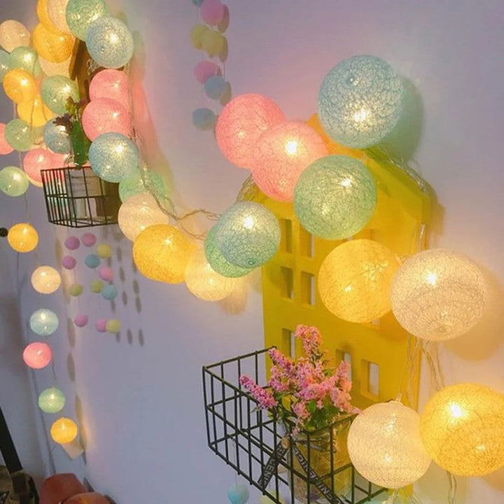 Guirnalda de luces LED con bolas, resaltando detalles decorativos con luz.