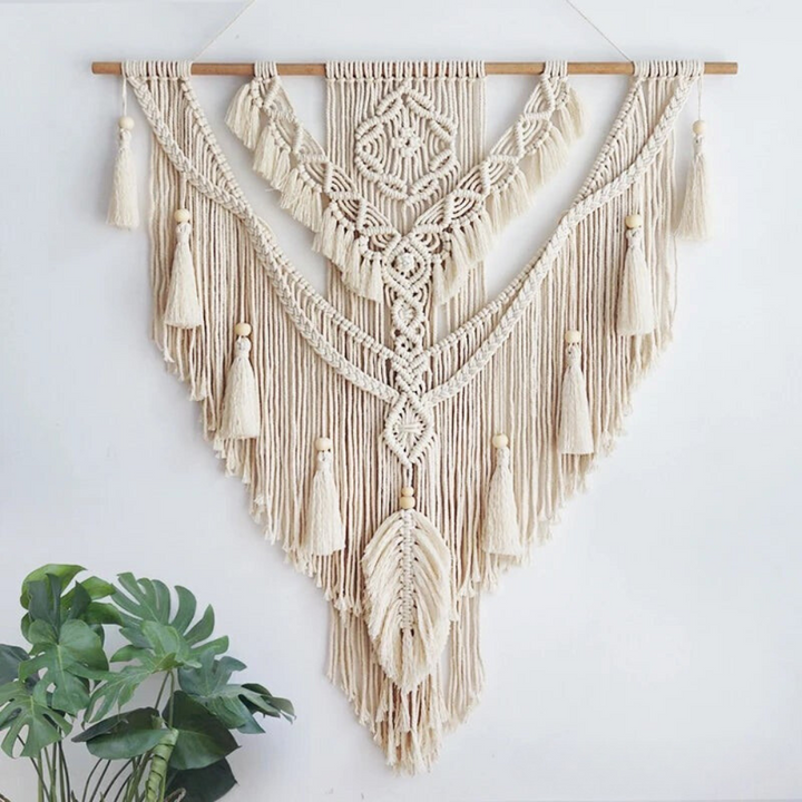 Arte artesanal de macramé tejido a mano, diseño boho escandinavo en tonos beige y amarillo para decoración interior.