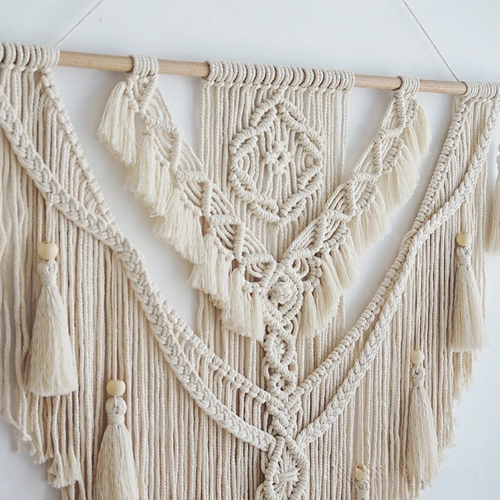 Decoración de pared de macramé estilo boho escandinavo, colgante hecho a mano con detalles tejidos en beige y amarillo.
