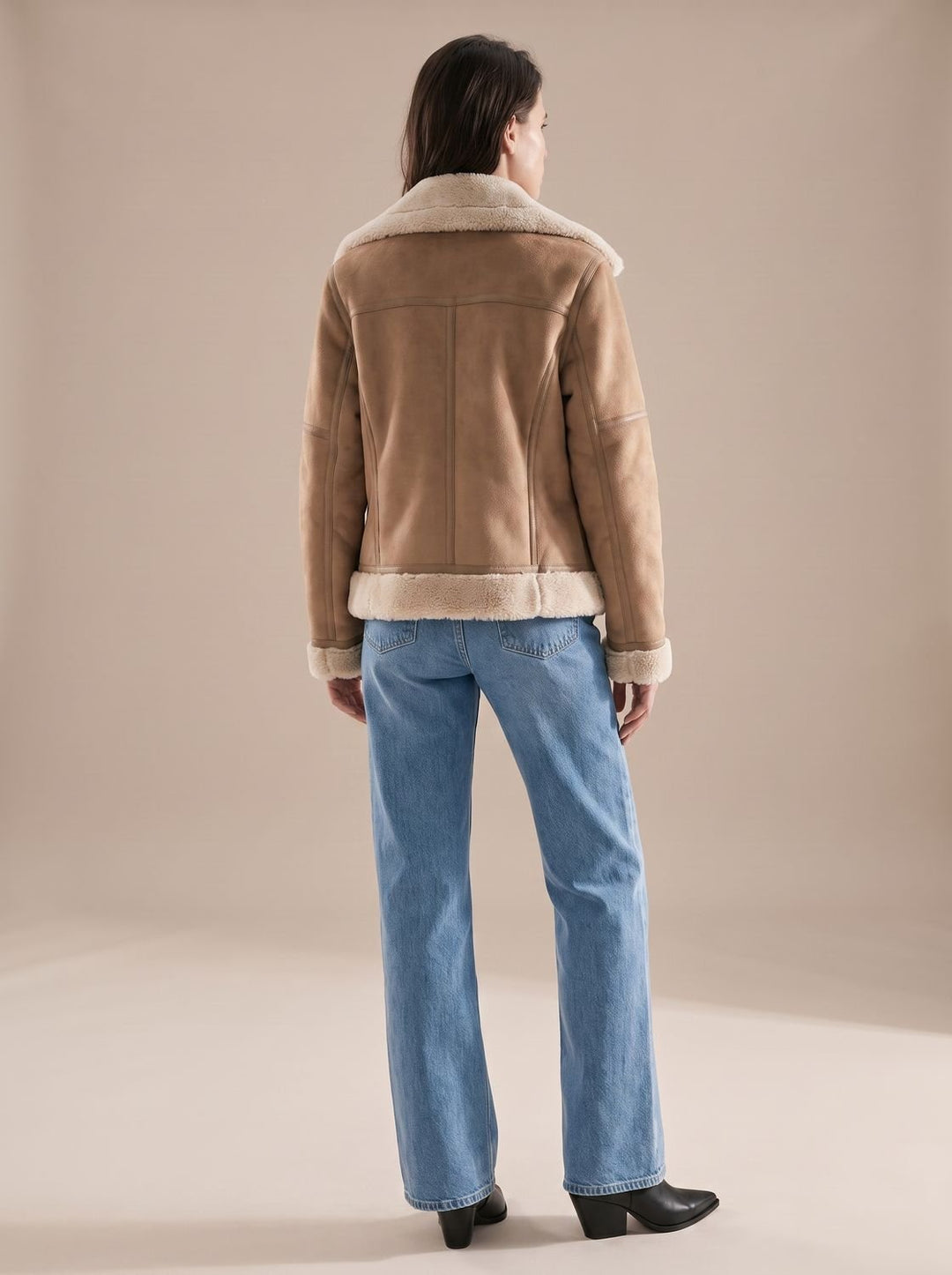 Primer plano de chaqueta aviador de borreguito sintético, con cinturón y cuello cálido para mujer.