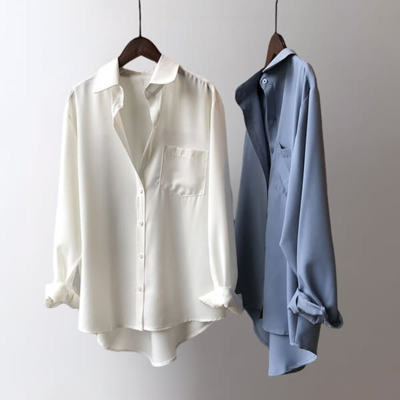 Detalle de blusa sedosa de satén para mujer, con cuello y puños elegantes.