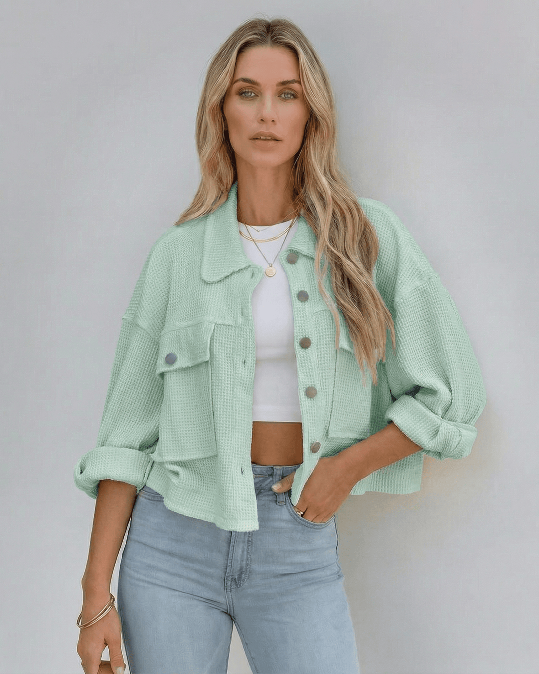 Elegante chaqueta verde menta para mujer, con diseño recortado y silueta oversized. Tendencia de moda casual.