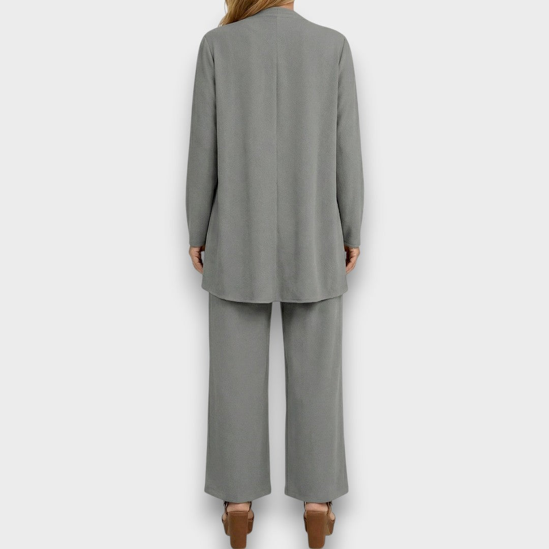 Vista completa del conjunto minimalista negro de 3 piezas para mujer: pantalón ancho, chaleco y blusa.