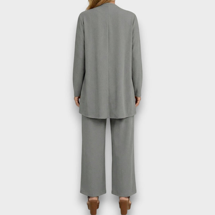 Vista completa del conjunto minimalista negro de 3 piezas para mujer: pantalón ancho, chaleco y blusa.