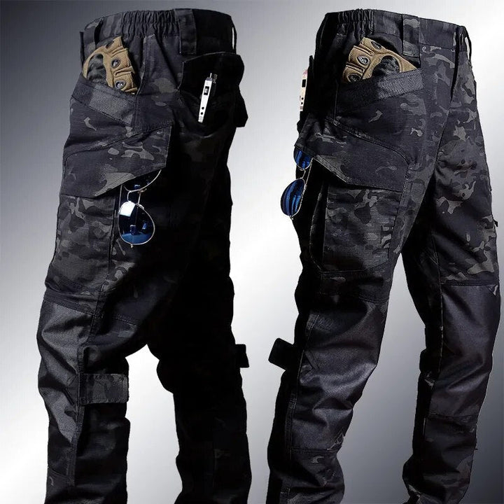 Hombre con conjunto táctico camuflaje para airsoft. Chaqueta y pantalón de ropa deportiva, listo para la aventura.