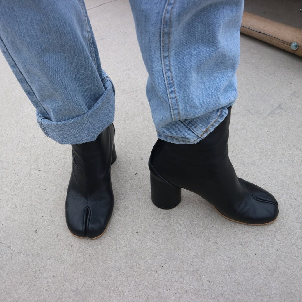 Botines tabi de mujer con distintiva punta dividida y tacón bloque. Botas tobilleras elegantes, calzado vanguardista.