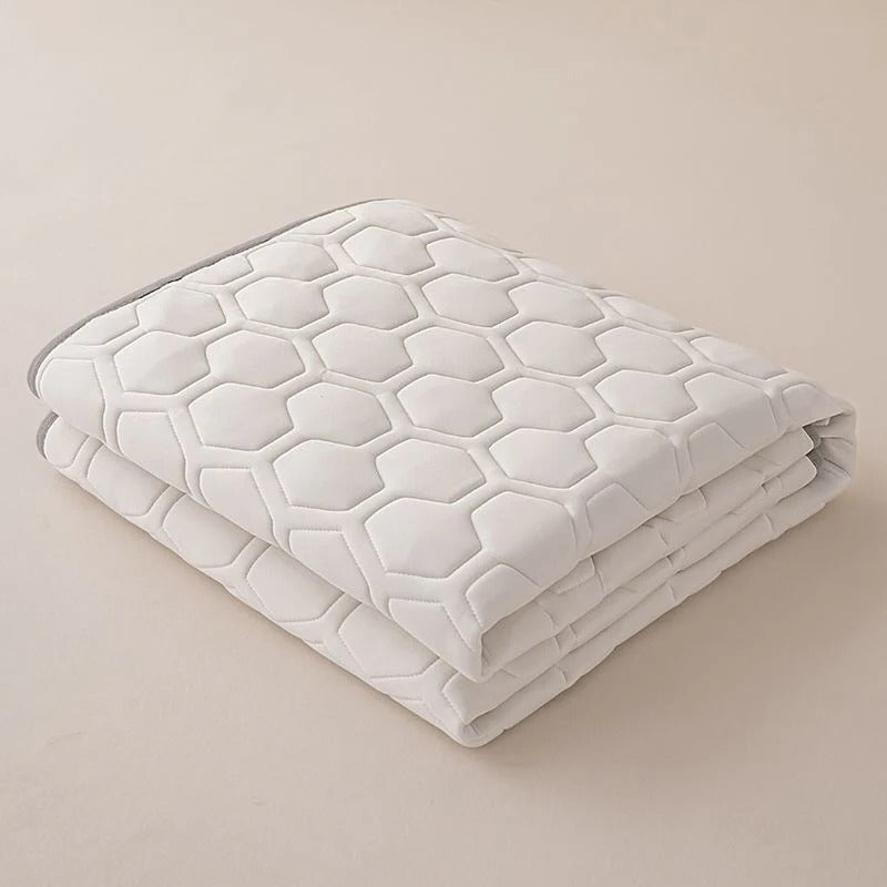 Protector de colchón refrigerante extendido sobre una cama limpia, listo para ofrecer un descanso fresco.