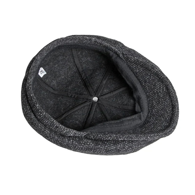 Gorra plana estilo caballero en gris, un accesorio masculino vintage que complementa la moda clásica.