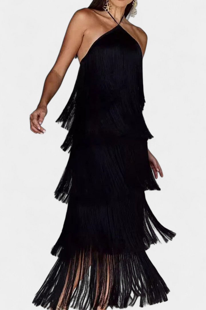 Mujer luciendo vestido de fiesta con flecos en movimiento y espalda abierta, estilo halter moderno.