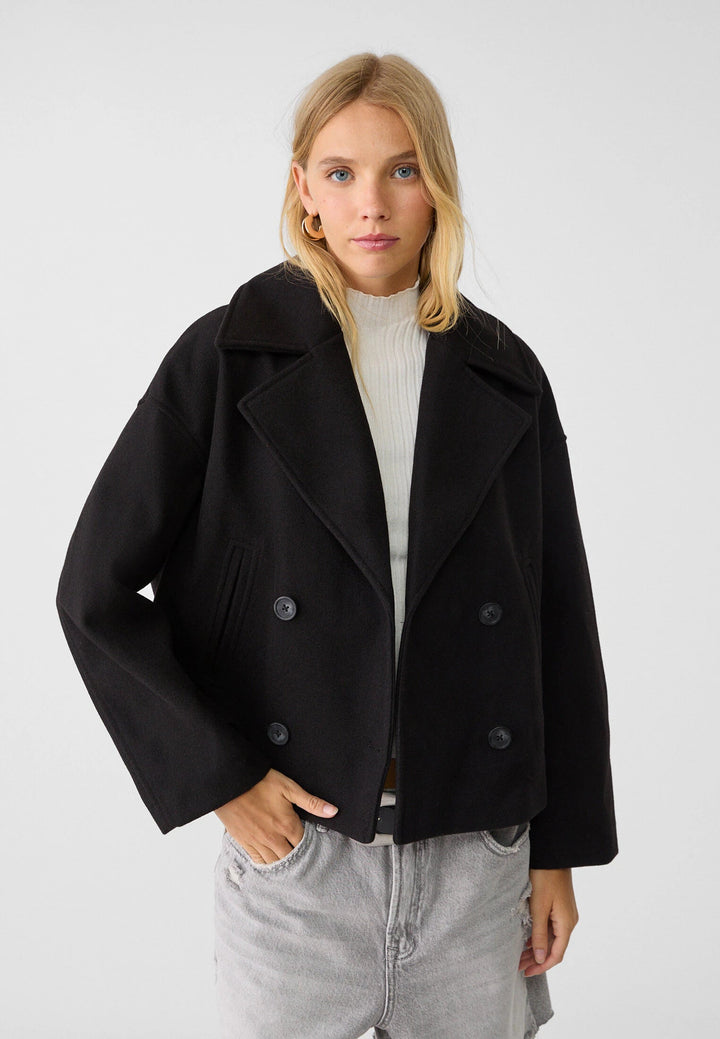 Abrigo negro de doble botonadura para mujer. Chaqueta de invierno elegante, estilo versátil.