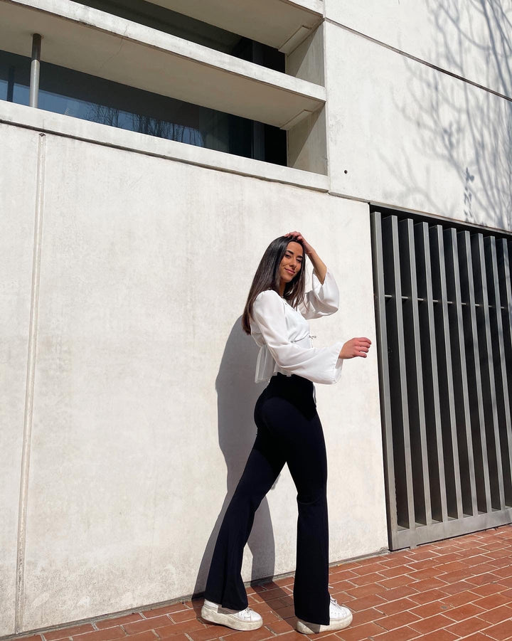 Elegante pantalón negro campana de mujer, tiro alto que realza la cintura.