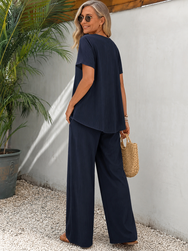 Ropa casual chic para mujer: conjunto dos piezas fluido con top asimétrico y pantalón ancho.