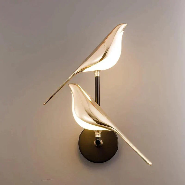Lámpara de pared con figura de colibrí dorado, diseño único y elegante para luz y decoración del hogar.