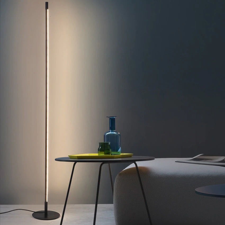 Iluminación moderna con lámpara de pie LED minimalista, tubo delgado de aluminio, para decoración de sala o estudio.