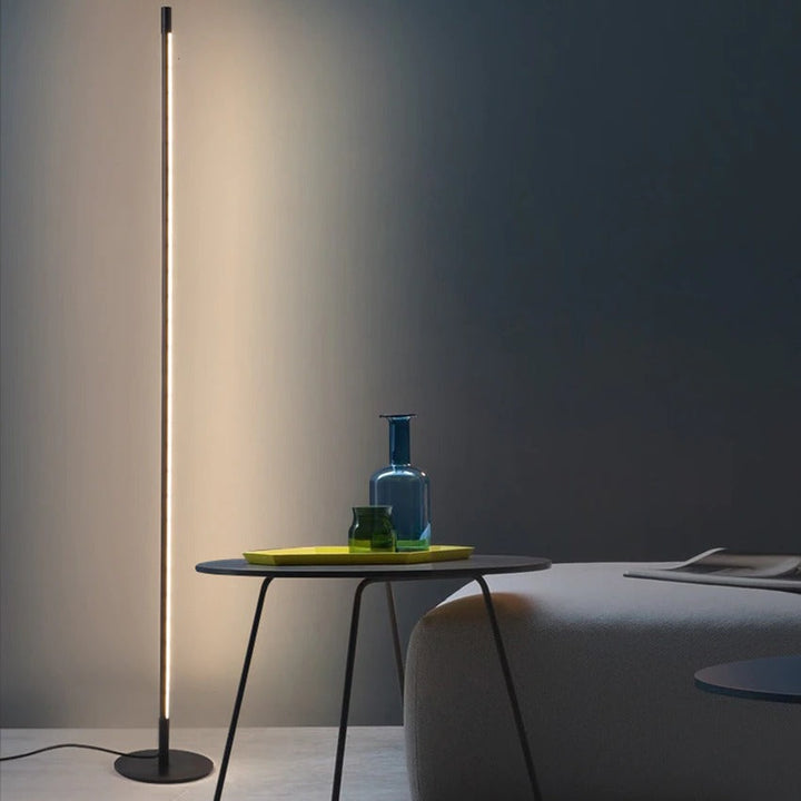 Iluminación moderna con lámpara de pie LED minimalista, tubo delgado de aluminio, para decoración de sala o estudio.