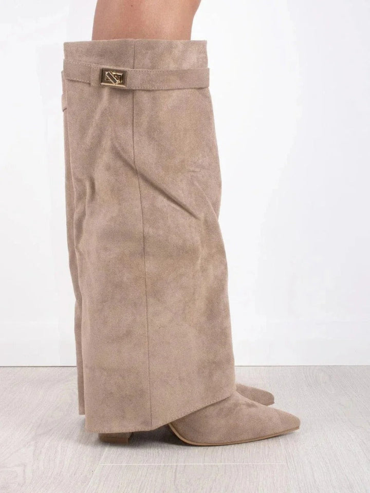 Mujer luciendo botas altas de ante, mostrando el calce perfecto y el estilo moderno del calzado.