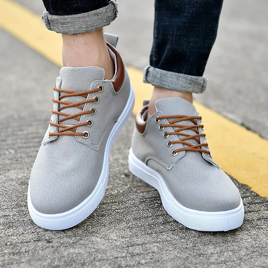 Vista frontal de zapatillas de hombre con cordones y suela blanca estilosa, para un look urbano impecable.