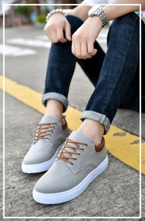 Primer plano del tejido superior de zapatillas urbanas para hombre, junto a la suela blanca y estilosa.