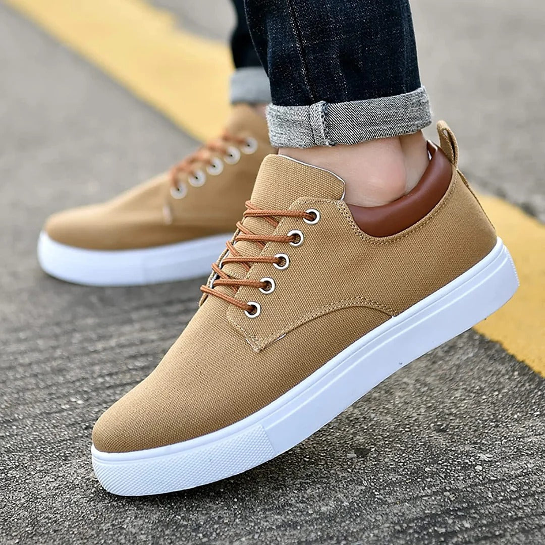 Primer plano de zapatillas urbanas de hombre con suela blanca estilosa, destacando detalles del material.