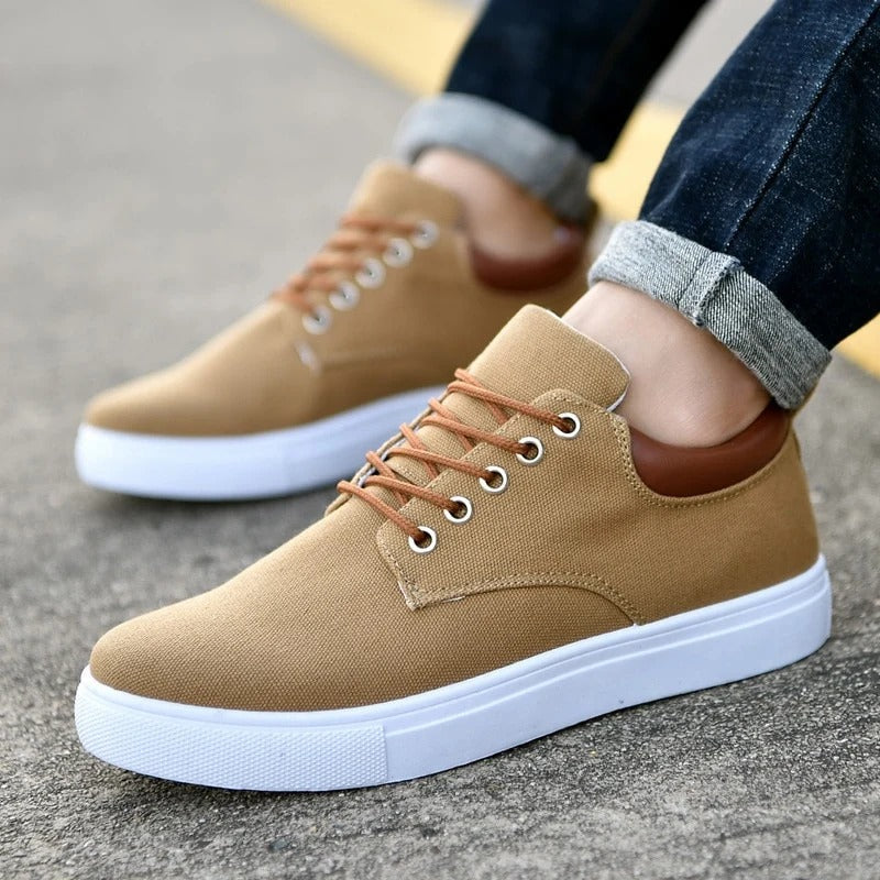 Vista lateral de zapatillas urbanas de hombre, mostrando suela blanca y el perfil estilizado. Calzado moderno.