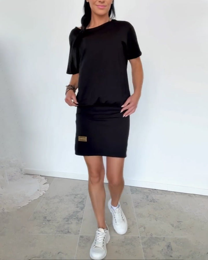 Vestido corto casual de mujer, vista lateral mostrando ajuste cómodo y elástico, estilo chic.