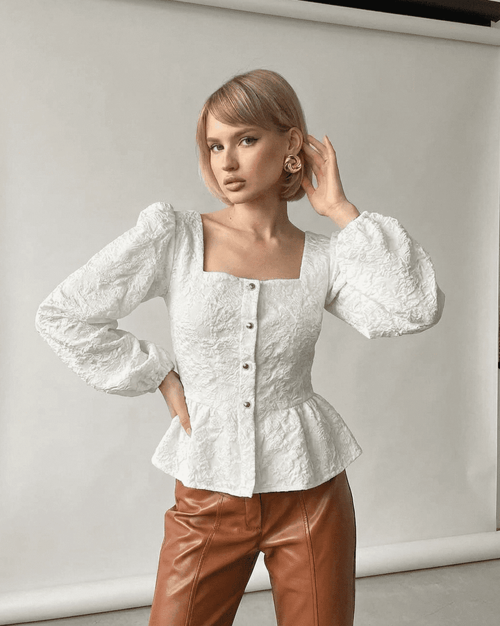 Top corsé marfil de mujer con elegantes mangas abullonadas, estilo chic.
