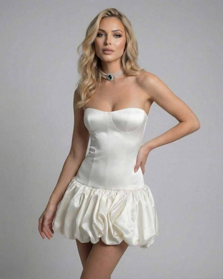Vestido de fiesta marfil, estilo mini sin tirantes, silueta ceñida y sexy espalda al descubierto.
