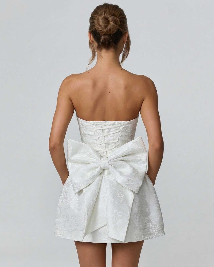 Vestido mini acampanado marfil sin tirantes, ideal para verano y estilo preppy.