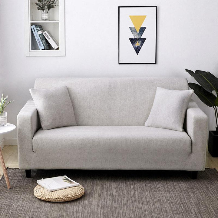 Funda elástica marfil para sofá, protege y renueva la decoración de tu sala de estar.