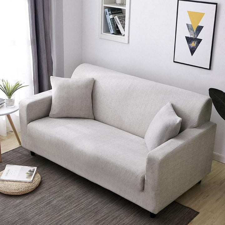 Protector de sofá elástico color marfil, de fácil instalación para una protección duradera de muebles.