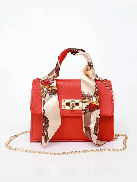 Bolso de mano sintético en tonos pastel con cadena plateada y pañuelo floral. Elegante para mujer.