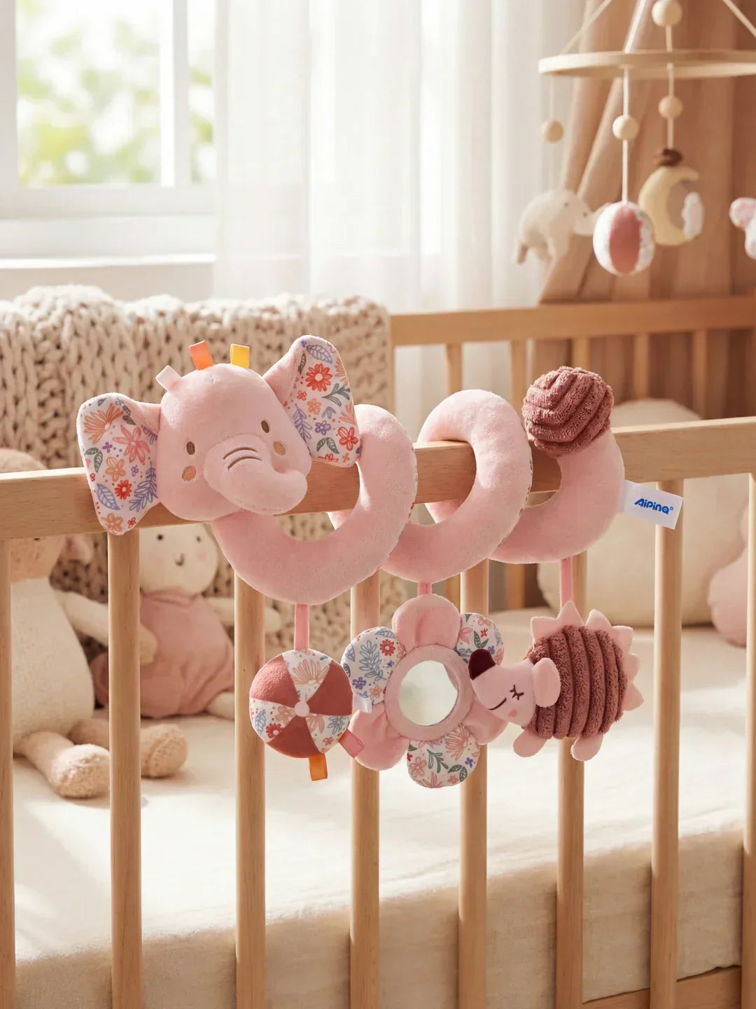 Espiral de actividades sensoriales para cuna de bebé, con colgantes suaves y sonajeros interactivos.