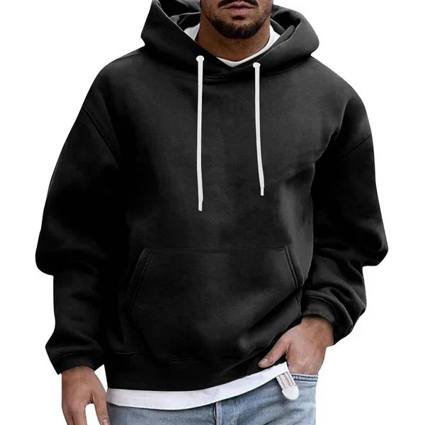 Hombre vistiendo sudadera oversize con capucha, estilo urbano y relajado. Perfecta para moda casual masculina.