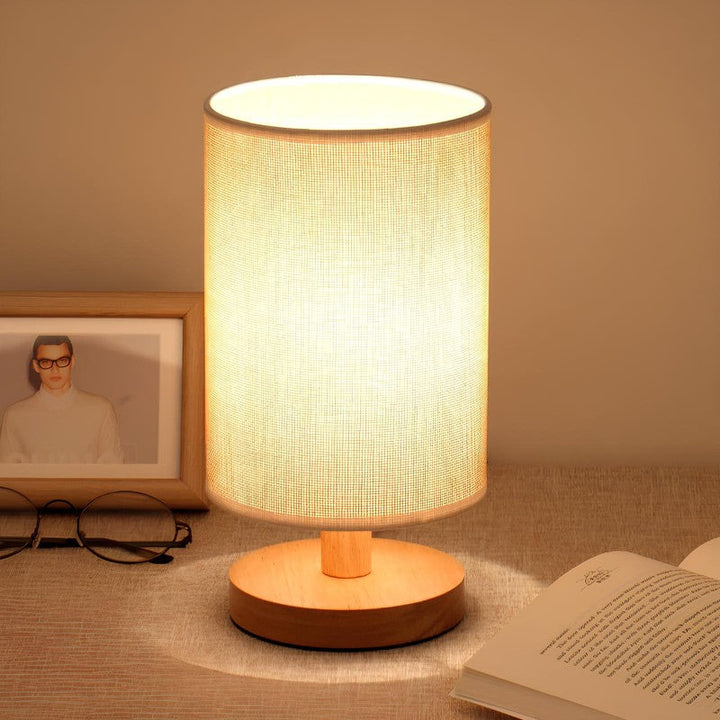 Lámpara de mesa LED cilíndrica táctil con base de madera, ideal para iluminación interior moderna.