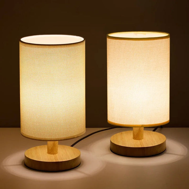 Lámpara de mesa LED con base de madera, diseño cilíndrico y control táctil para iluminación moderna.