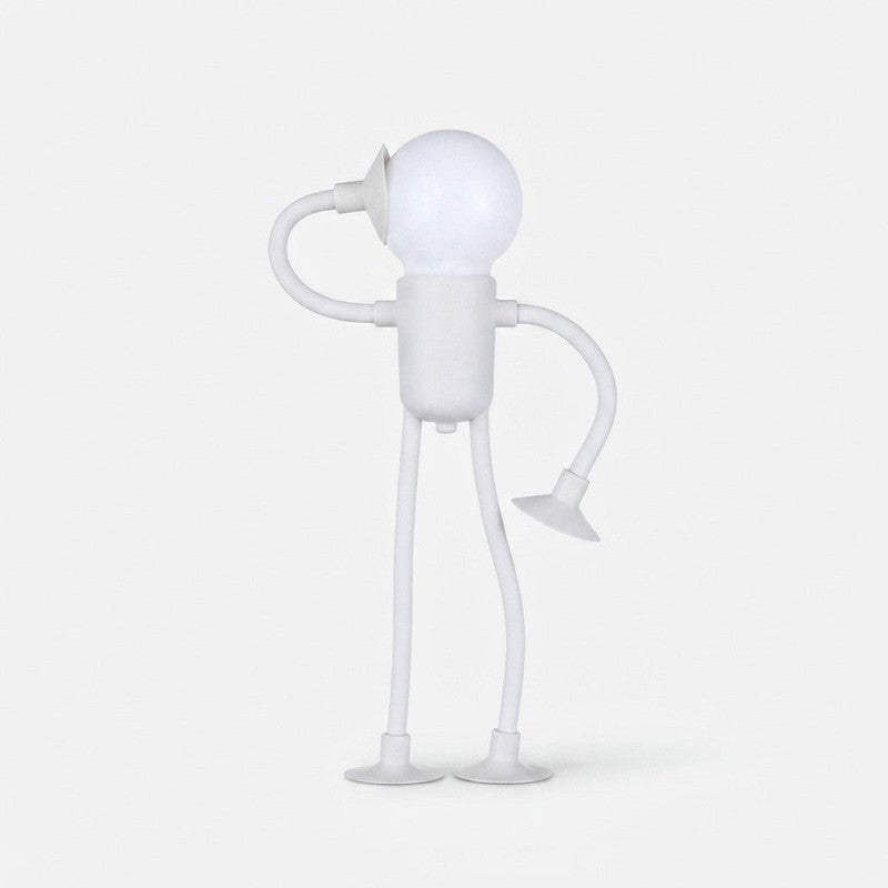 Lámpara de mesa LED con figura humana articulada, emite luz cálida, ideal para lectura o ambiente.
