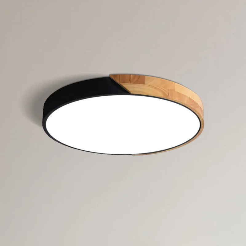 Iluminación interior: lámpara LED de techo redonda, borde de madera, toque minimalista.