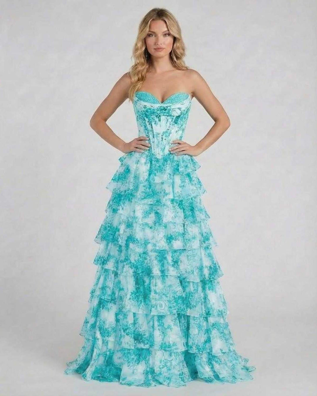 Mujer luciendo vestido maxi floral turquesa elegante, con diseño sin tirantes y silueta fluida para fiestas.