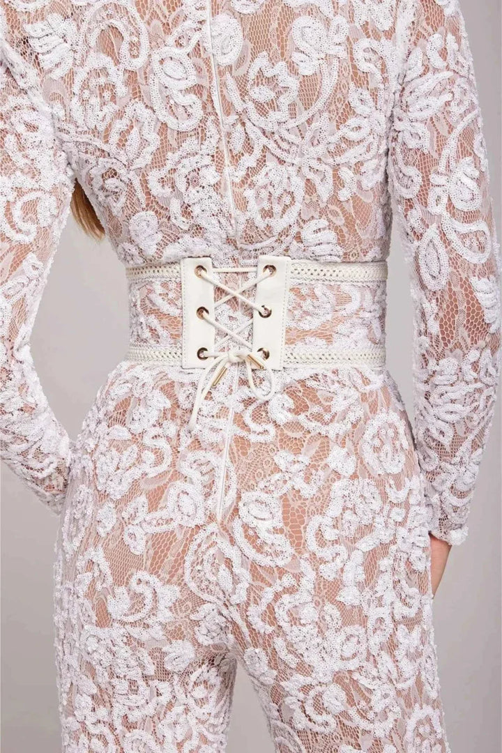 Mujer vistiendo mono elegante de encaje negro con manga larga, perfecto para eventos especiales de noche.