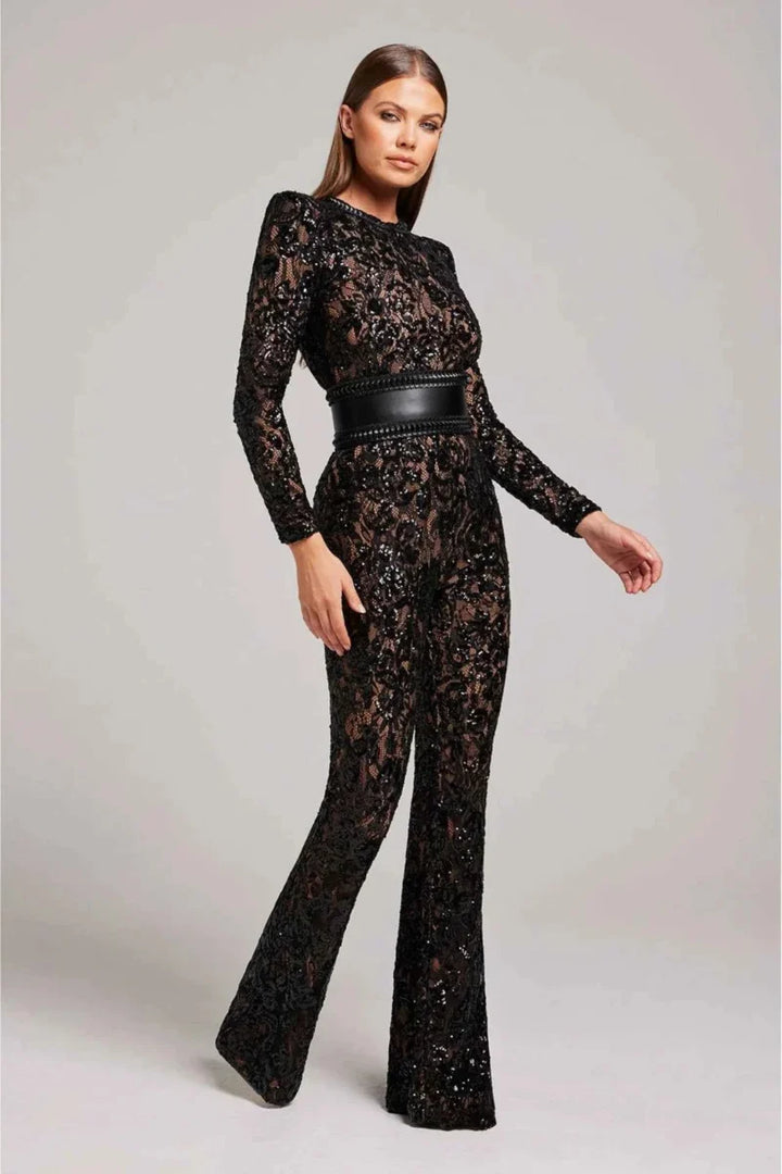 Detalle de encaje floral en mono negro de manga larga, diseño elegante para mujer. Look sofisticado.