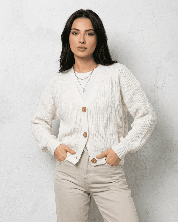 Cárdigan blanco de mujer, diseño clásico con cuello V, una prenda esencial de moda femenina atemporal.