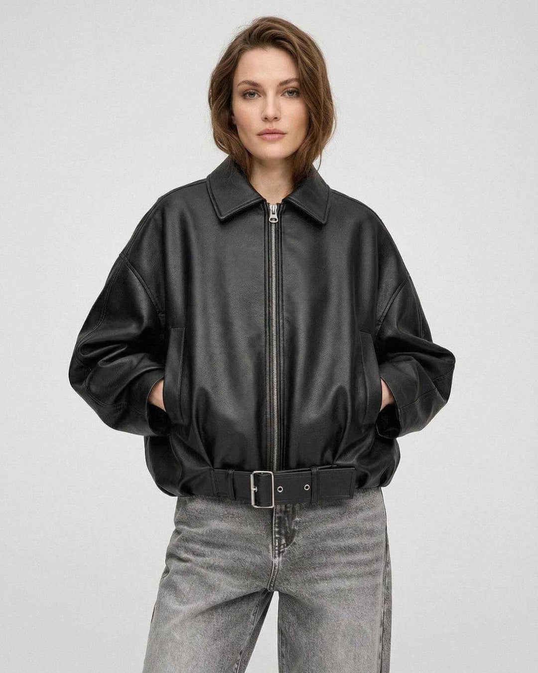 Chaqueta negra moderna de mujer con cinturón, estilo oversized urbano, ideal para primavera u otoño.