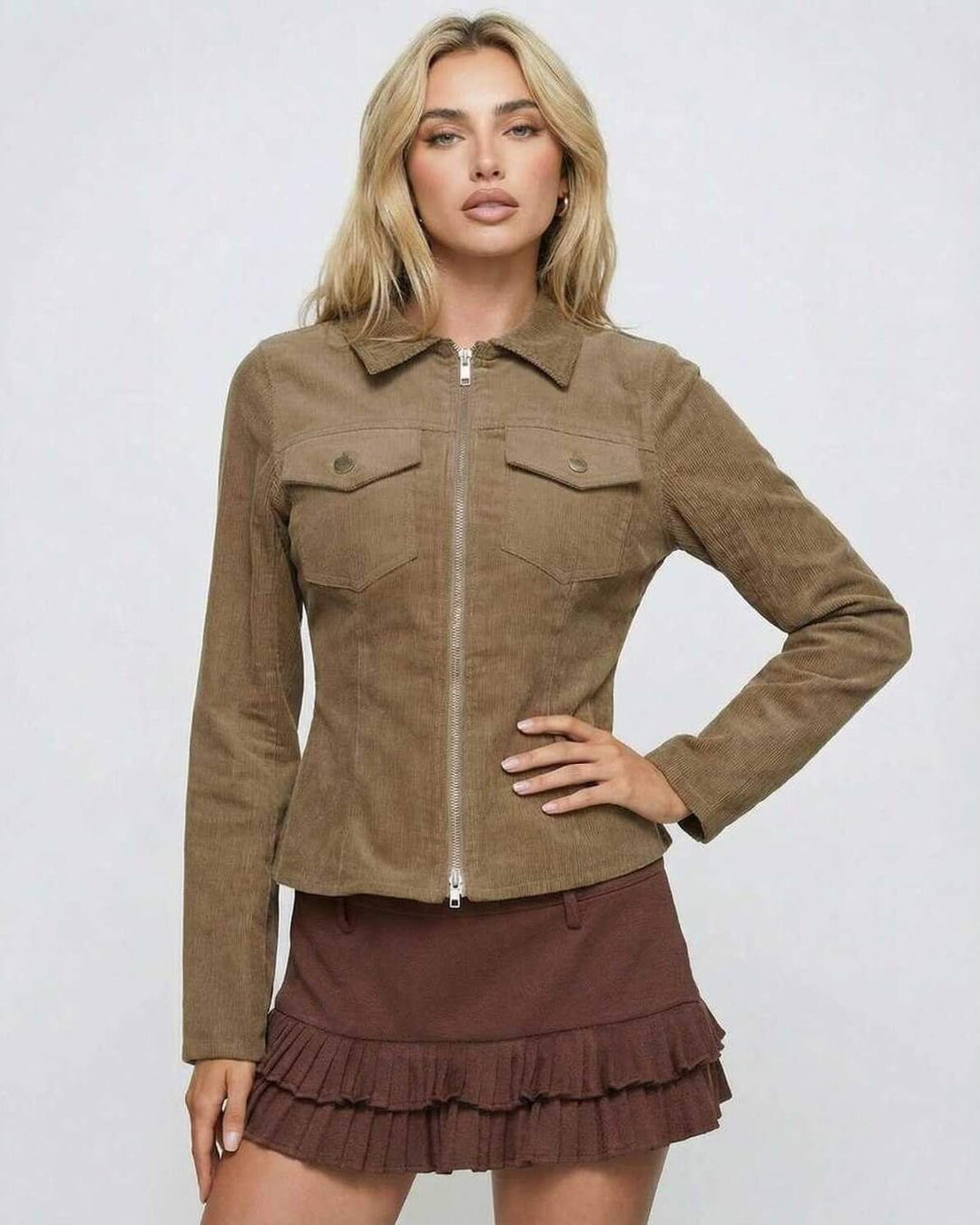 Chaqueta marrón con cremallera, diseño ajustado que realza la figura femenina. Vestuario versátil.