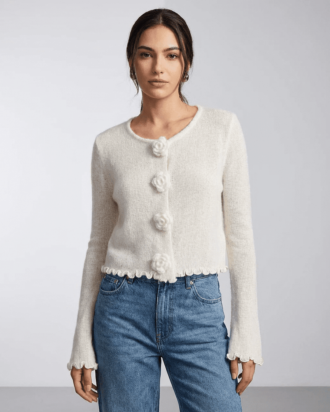 Mujer vistiendo un cárdigan blanco con botones florales, manga larga. Ideal para un estilo fresco y moderno.