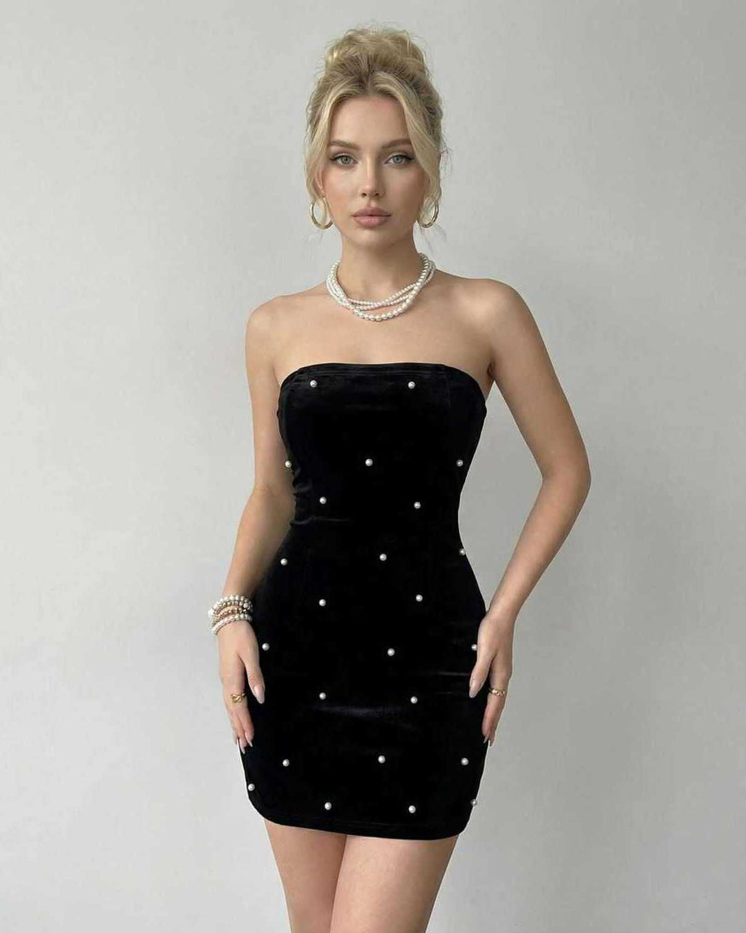 Vestido corto celeste de mujer, sin tirantes, con delicadas perlas. Perfecto para cócteles y celebraciones de fiesta.