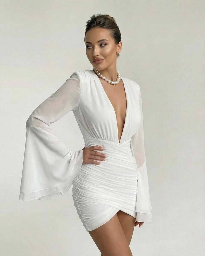 Vestido mini blanco elegante para eventos especiales. Destaca su escote V y sus modernas mangas acampanadas.