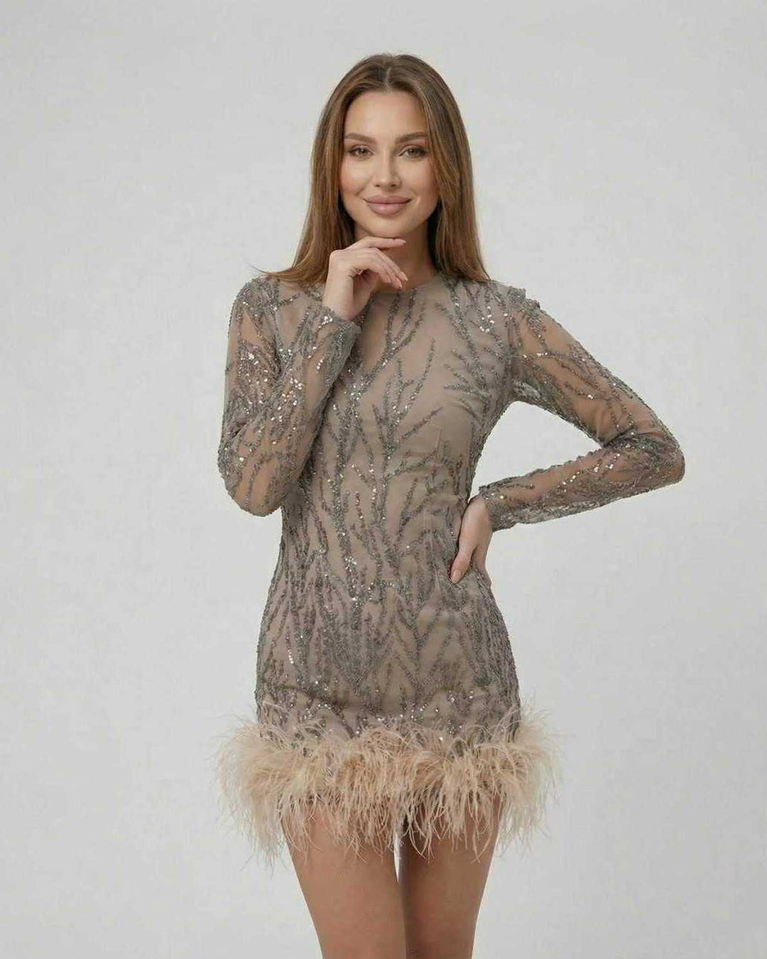 Detalle del mini vestido blanco para mujer, destacando lentejuelas iridiscentes y plumas suaves.